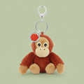 Plush orangutan keychain with a rose charm on a white background