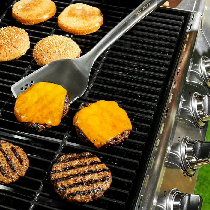 Cheeseburgers on a grill being flipped with a HexClad spatula.