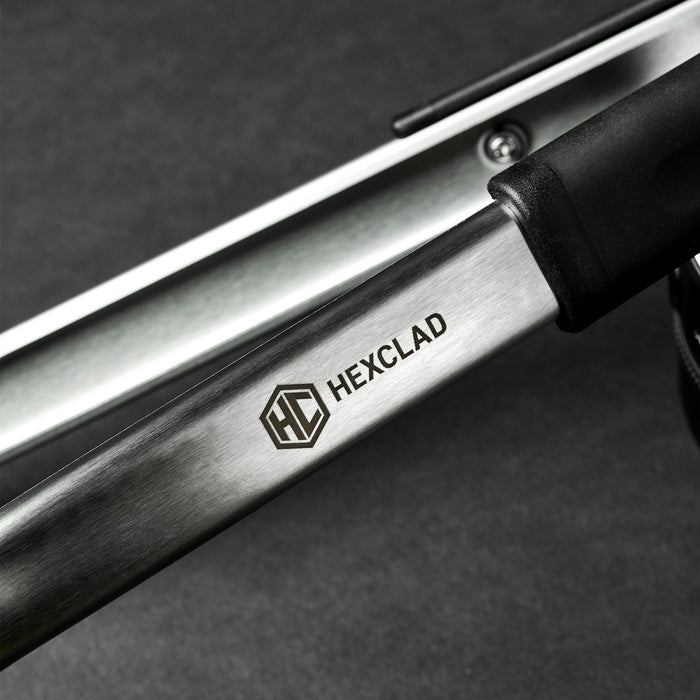 A closeup of the HexClad logo on a pair of tongs.