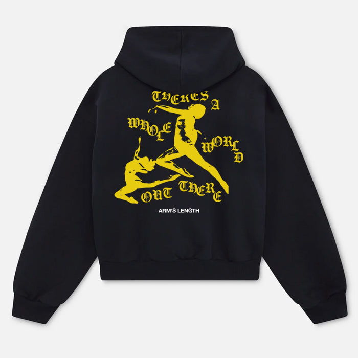A black Arm's Length hoodie with yellow silhouettes of two figures, ornate yellow text saying “THERE’S A WHOLE WORLD OUT THERE,” and “ARM’S LENGTH” in white at the bottom.