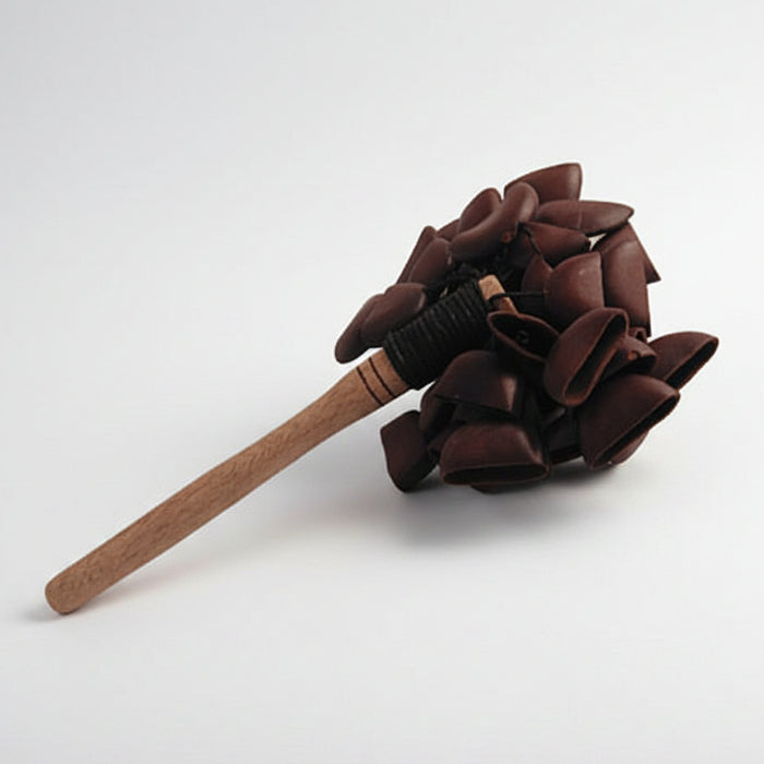 A wooden stick with a cluster of brown juju palm nuts bound at the end with twine.