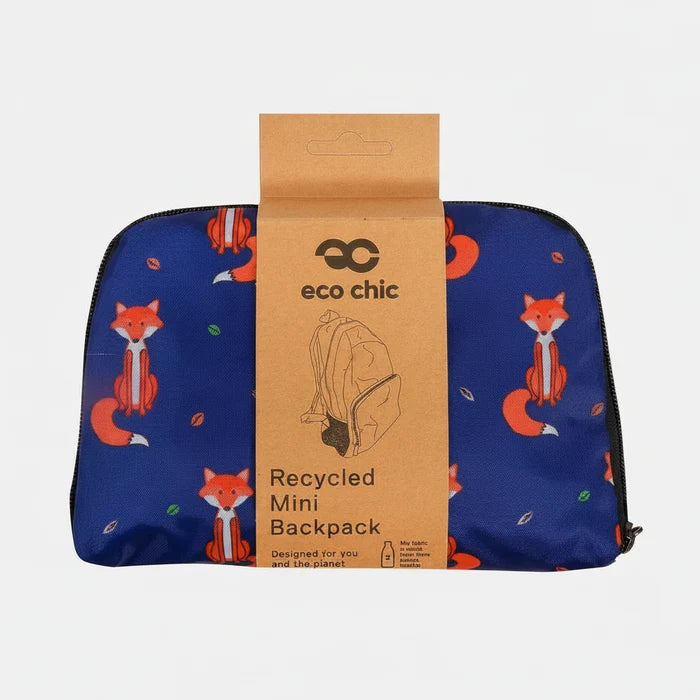 A blue mini backpack with a fox pattern, wrapped in a brown cardboard sleeve labeled 'eco chic Recycled Mini Backpack' on a white background.