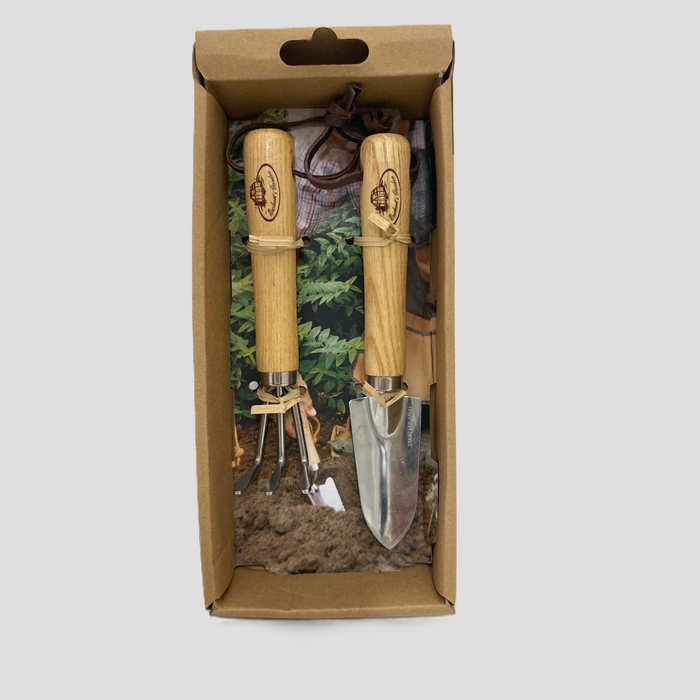 A 2-piece gardening tool set with wooden handles and stainless steel blades, presented inside its brown cardboard packaging box against a light gray background.
