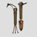 A miniature gardening tool set featuring a trowel and a three-pronged cultivator, both with dark brown faux-wood handles and bronze-colored metal heads, shown on a light gray background.