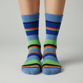 A pair of men's Moso bamboo socks with blue stripes, size 11-13, displayed on a cardboard stand.