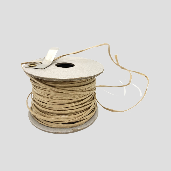 A spool of light tan paper wire, set against a solid light gray background.