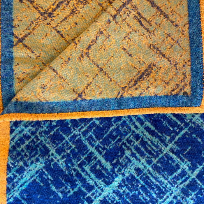 blanket detail reversable one side dark blue with light blue random lines the other side mustard with pale blue