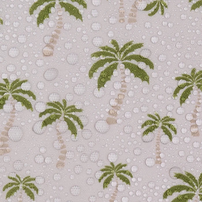 A close-up of a fabric pattern featuring green palm trees and raised white water droplets on a light beige background.