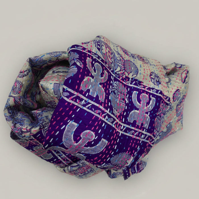 Folded fabric with blue and pink patterns on a beige background