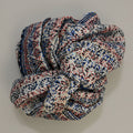 Folded scarf with a floral pattern on a textured beige surface