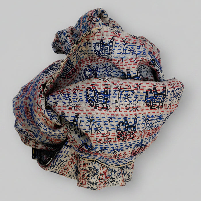 Folded scarf with intricate patterns on a textured beige background
