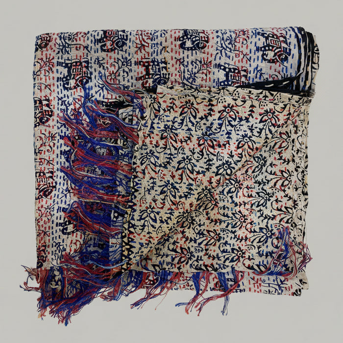 Decorative scarf with intricate patterns and tassels on a textured surface