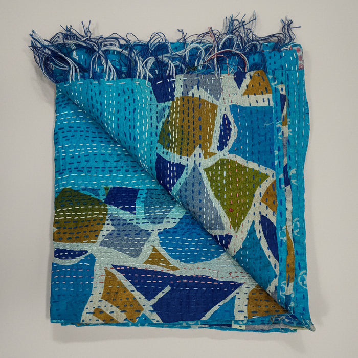 Folded scarf with blue and multicolor pattern on a grey background