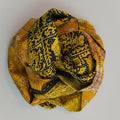 A yellow and gold silk sari scarf with floral patterns, displayed on a neutral background.