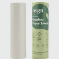Roll of white paper towels next to a green and white 'reign' branded box on a light gray background