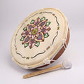 Decorative drum with mandala design and mallet on a white background