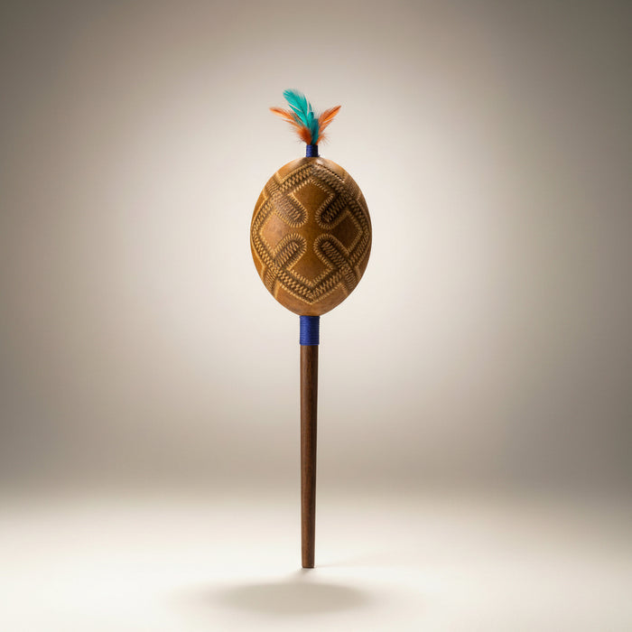 Decorative shaker gourd on stick, arved decoration on the gourd.
