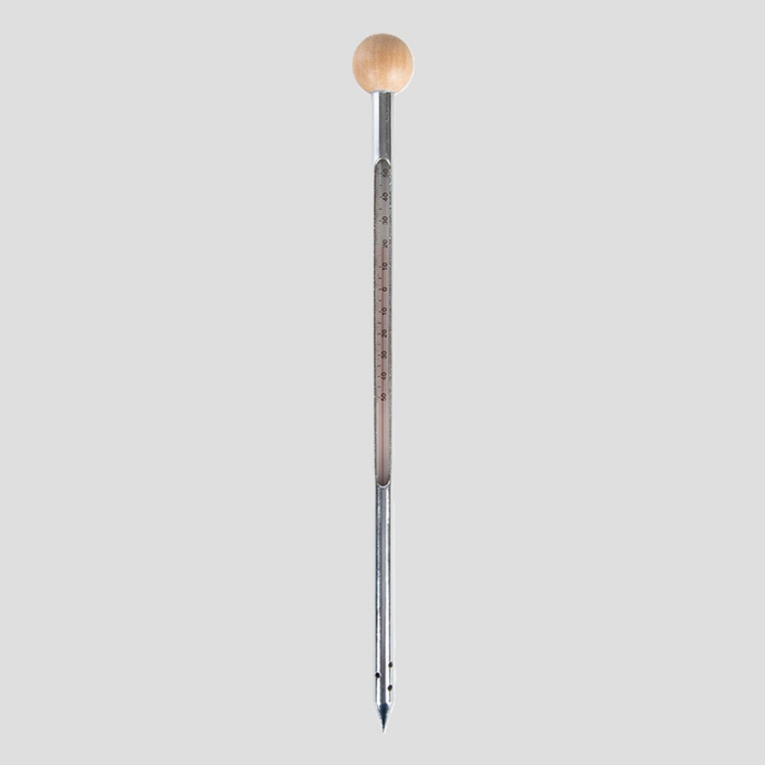 A vertical metal thermometer with a light wood ball at the top and a fine metal tube with printed temperature markings, centered on a solid gray background.