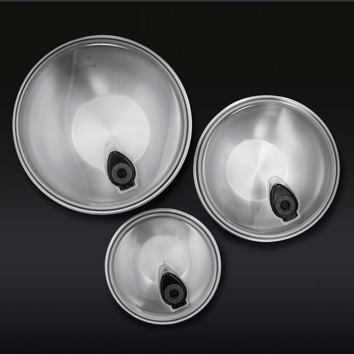 3 HexClad stainless steel mixing bowls with vacuum seal lids on a black background, shown from a bird's eye view.