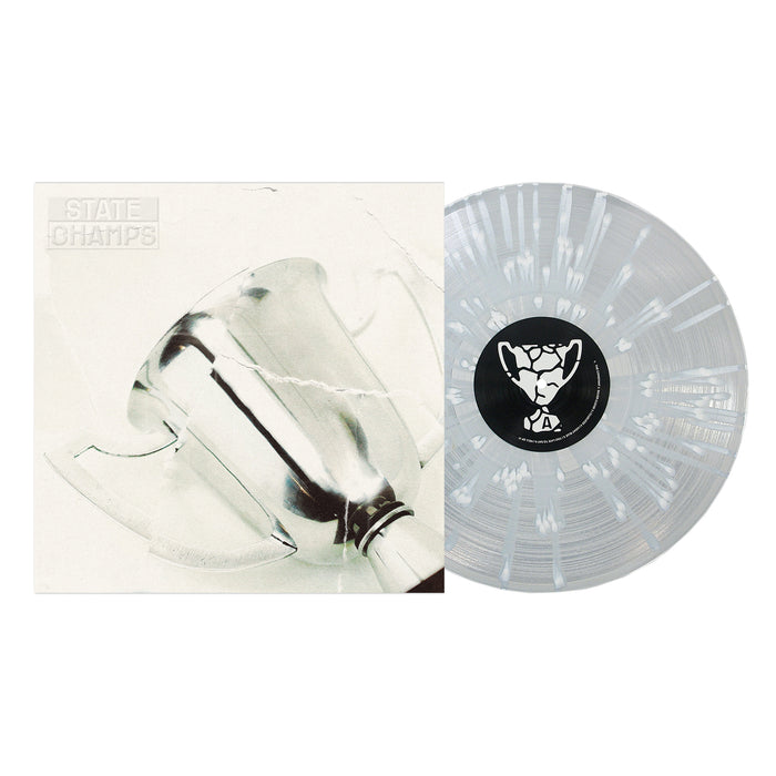 A clear white splatter vinyl record by State Champs sits next to its album cover, which displays a close-up of a silver trophy on a light background with "STATE CHAMPS" written in block letters.