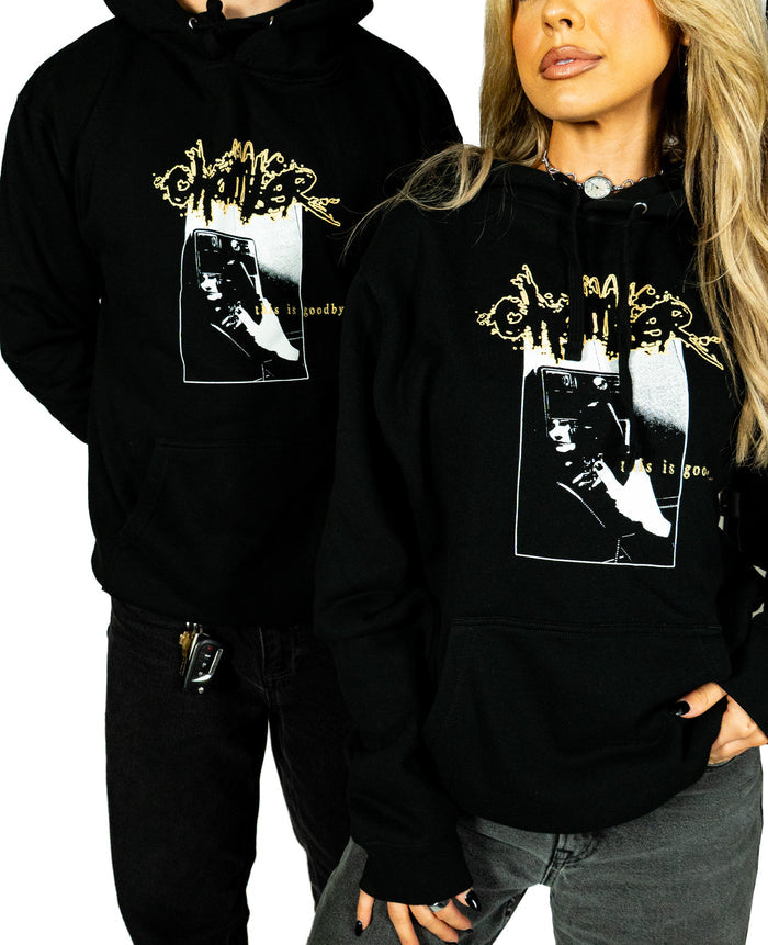 Two people wear matching black Chamber sweatshirts with a graphic design and text. Both have their hands in their pockets. Their bodies are shown from mid-thigh up against a white background.