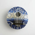 A colorful thumb piano with metal tines and a blue patterned surface.